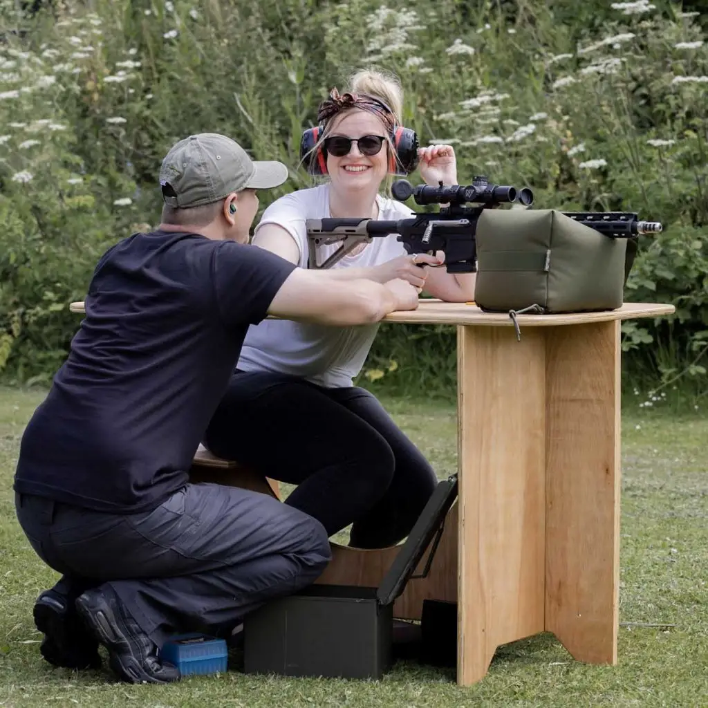 Participant smiling whilst being instructed in shooting technique